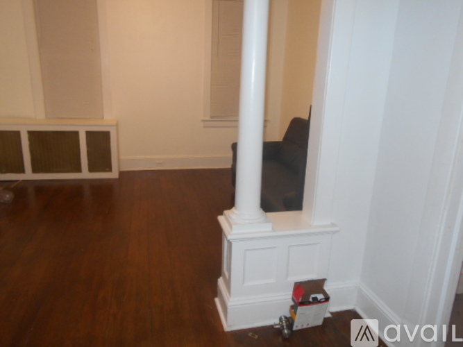 A room with wooden flooring and white walls.