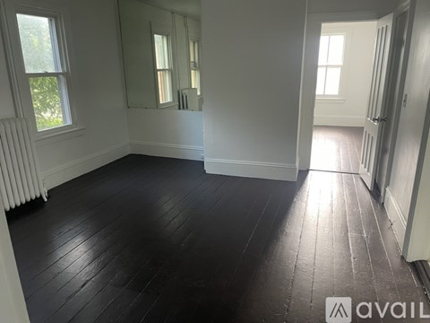 A room with white walls and a wooden floor.