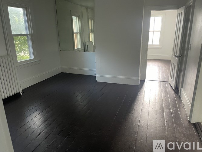 A room with white walls and a wooden floor.