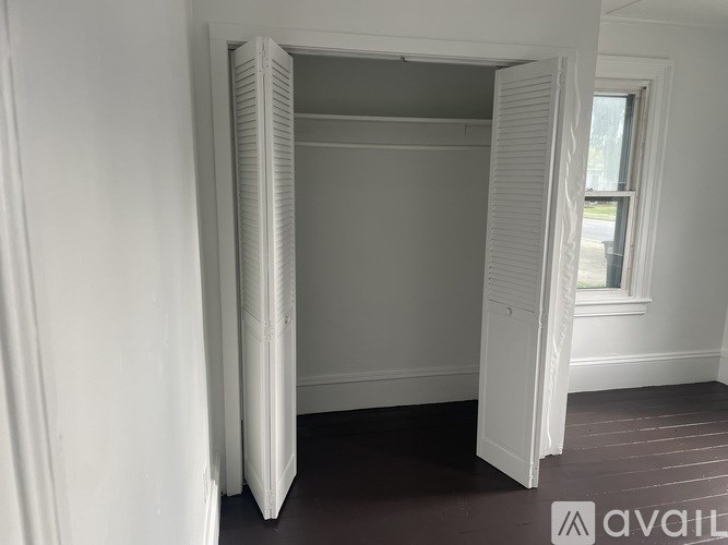 A room with a white door and a window.