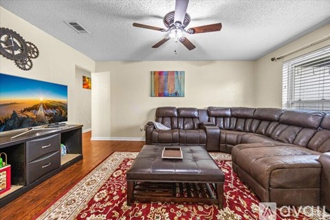 A living room with a brown leather couch and a coffee table.