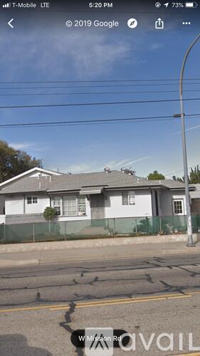 A house with a white fence and a grey roof is visible.