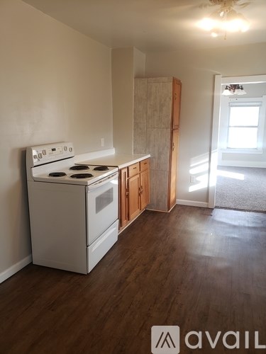 A kitchen with a white stove and wooden cabinets.