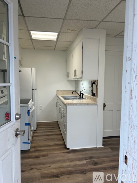 A kitchen with white cabinets and a sink.