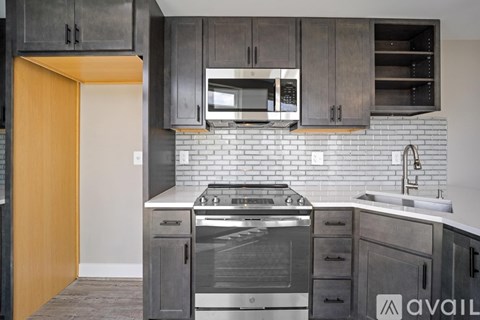 A kitchen with a stove top oven and a microwave above it.