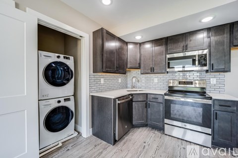 A modern kitchen with dark wood cabinets and stainless steel appliances.