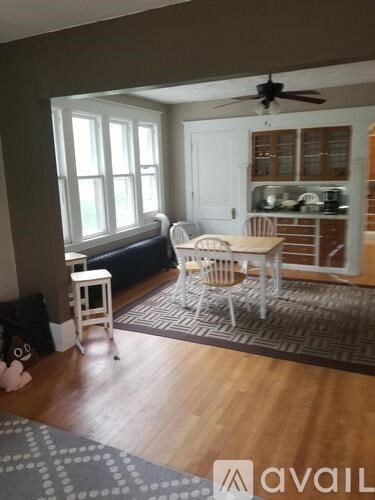 A living room with a white chair and a grey rug.