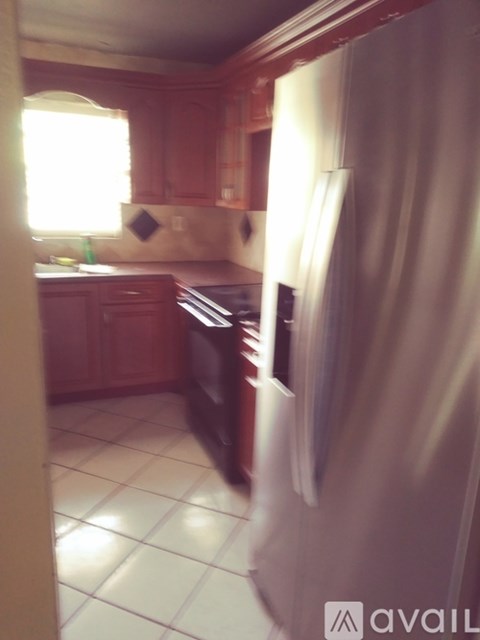 A kitchen with wooden cabinets and a white refrigerator.