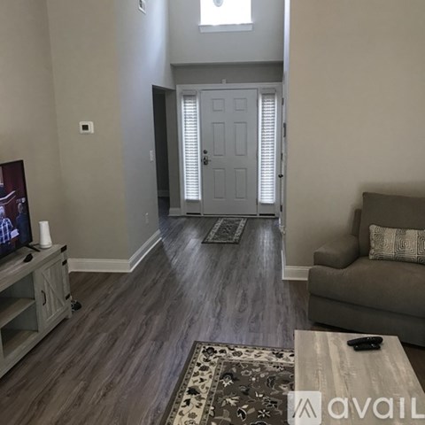 A living room with a grey couch and a wooden coffee table.