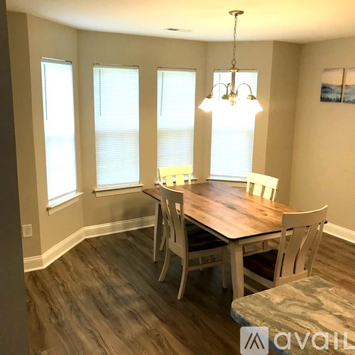 A dining room with a wooden table and chairs.