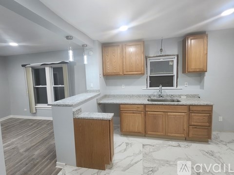 A kitchen with wooden cabinets and a marble countertop.