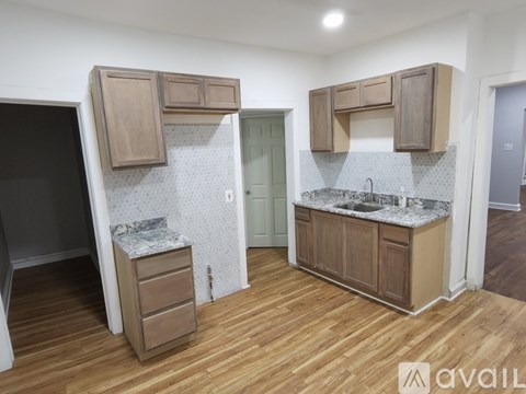 A kitchen with wooden cabinets and a marble countertop.
