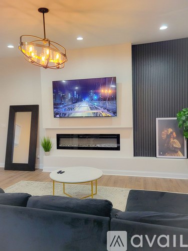 A modern living room with a fireplace and a large painting on the wall.