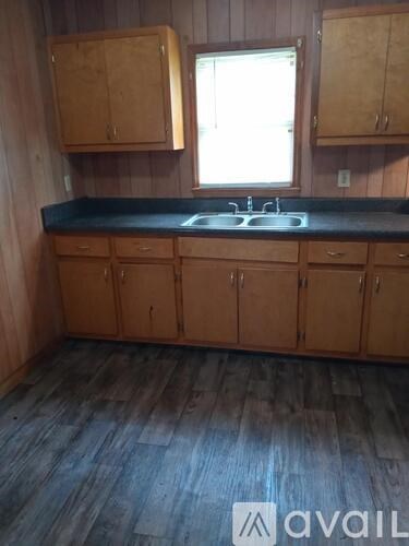 A kitchen with wooden cabinets and a black countertop.