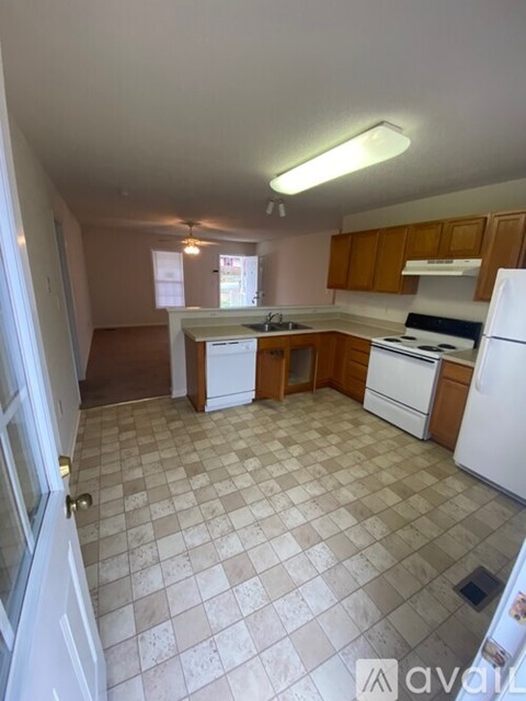 A kitchen with white appliances and brown cabinets.