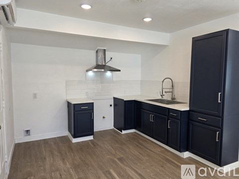 A kitchen with dark wood cabinets and a stainless steel range hood.