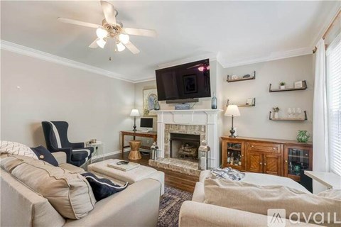 A living room with a fireplace and a television on the wall.