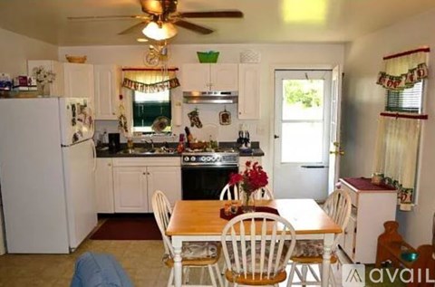 A kitchen with a table and chairs in front of it.