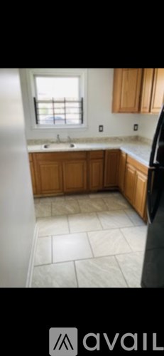 A kitchen with wooden cabinets and a window.