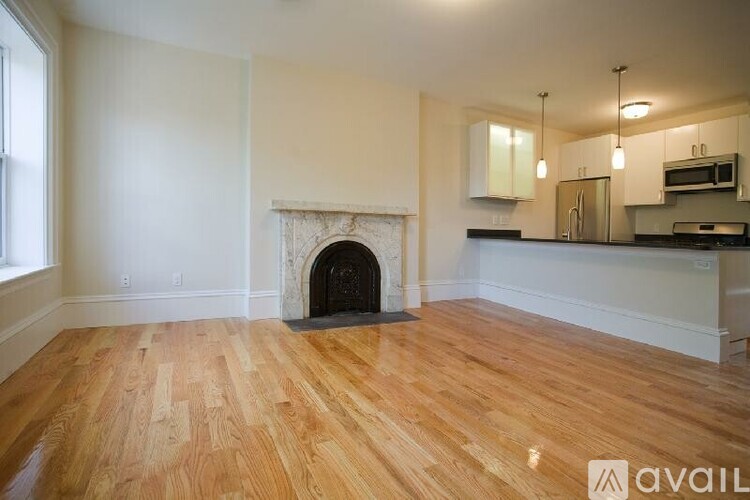 A living room with a fireplace and wooden floors.
