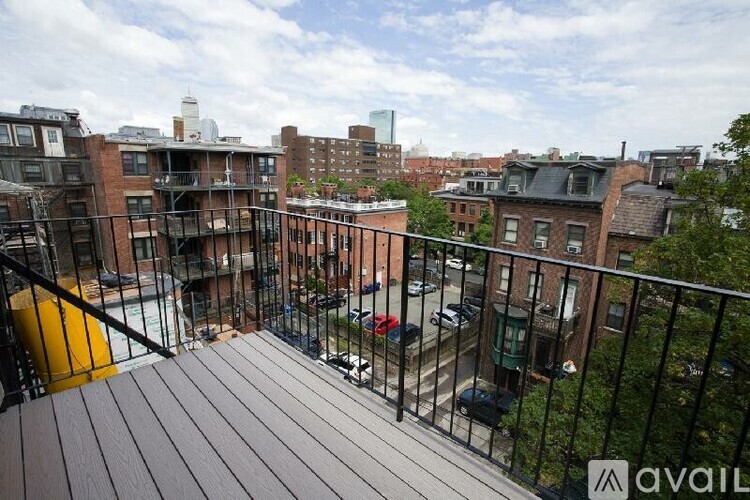 A balcony with a railing overlooks a city street.