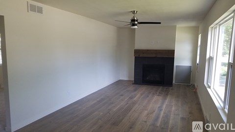 A room with a fireplace and a ceiling fan.