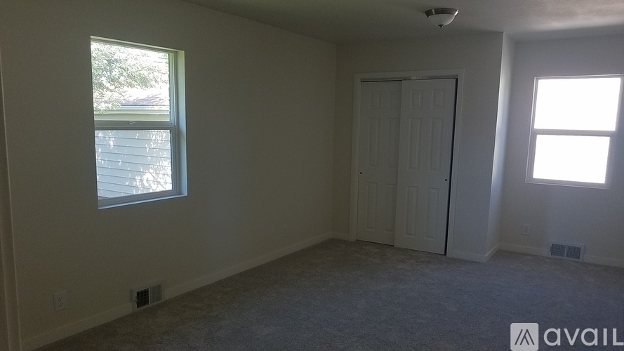 A room with a window and a door is available for rent.