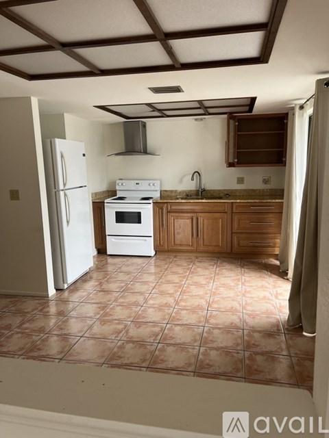 A kitchen with a white fridge and stove top oven.