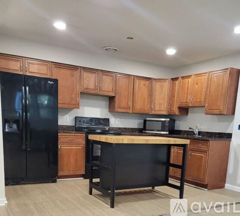 A kitchen with wooden cabinets and black appliances.