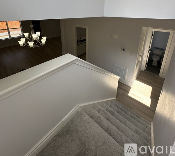 A staircase with a carpeted runner and wooden steps leads up to a second floor.