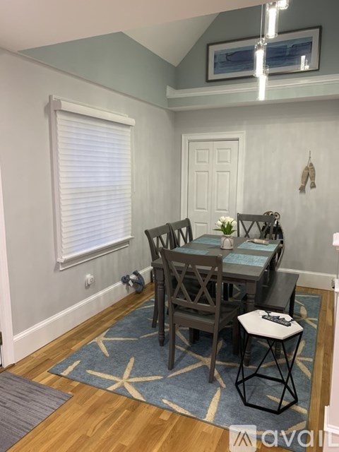 A dining room with a table and chairs.