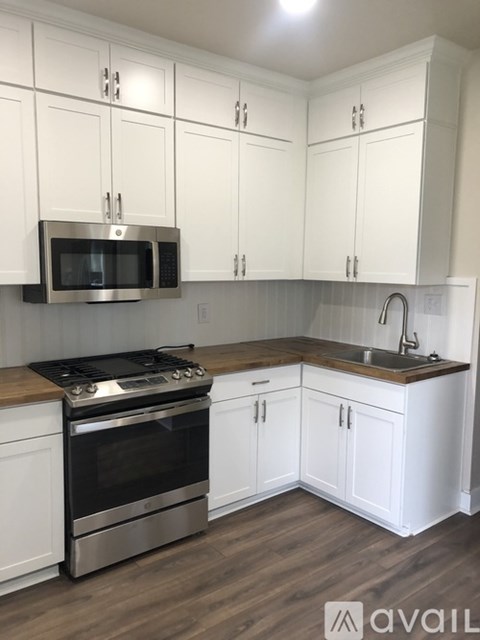 A kitchen with white cabinets and a stainless steel oven.
