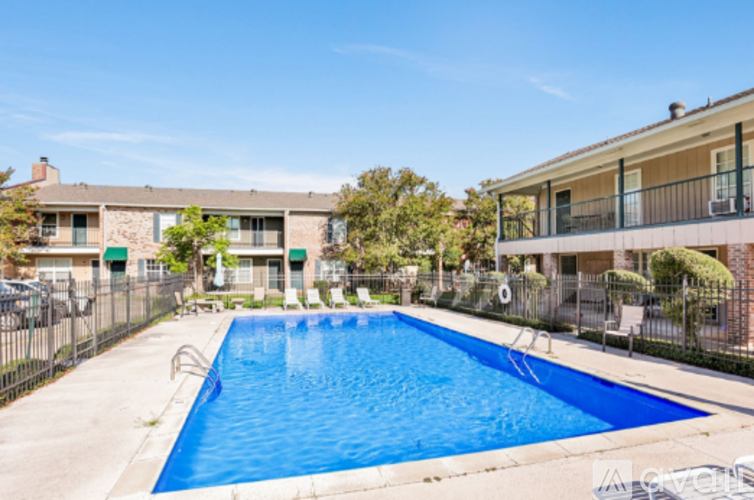 A blue swimming pool in front of a building with a fence around it.
