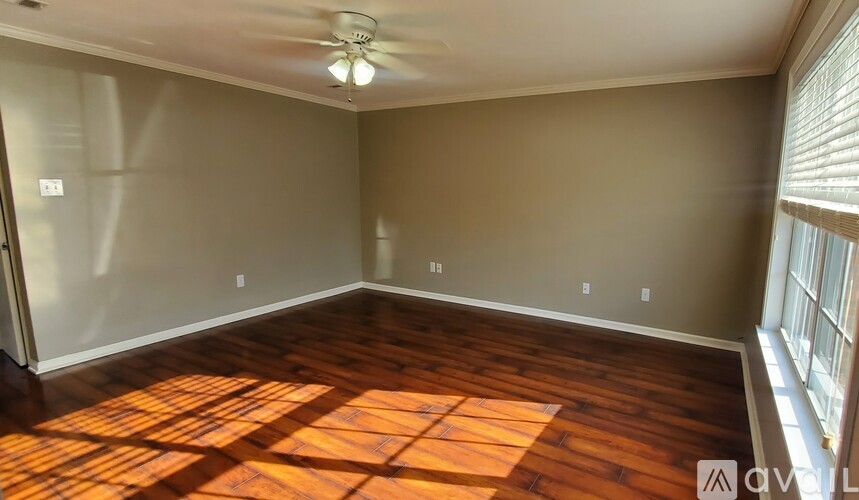 A room with wooden flooring and a ceiling fan.