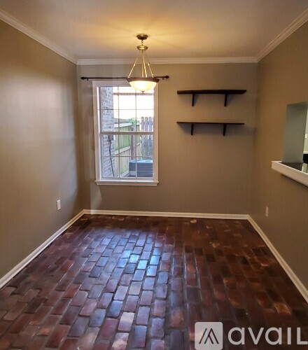 A room with a window and wooden flooring.