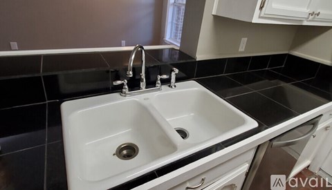 A white sink with a silver faucet in a modern kitchen.