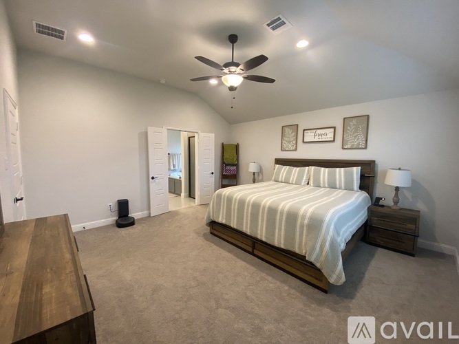 A bedroom with a bed, nightstand, and a ceiling fan.