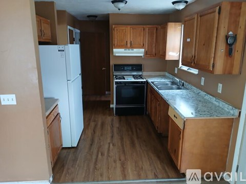A kitchen with wooden cabinets and a white refrigerator.