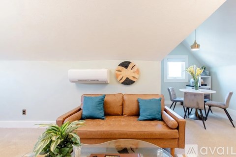 A living room with a brown couch and a blue pillow.