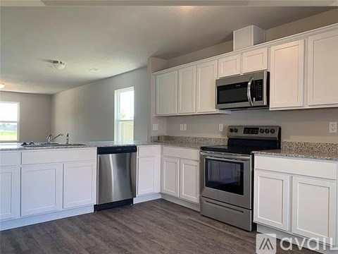 A kitchen with white cabinets and stainless steel appliances.