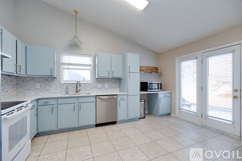 A kitchen with blue cabinets and white appliances.