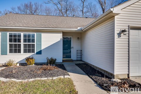 A house with a white garage door and a small front yard.