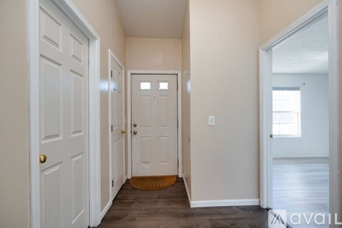 A hallway with a door on the left and a door on the right.
