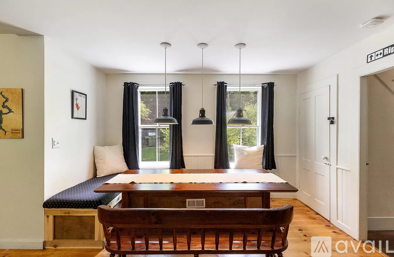 A dining room with a wooden table and chairs.