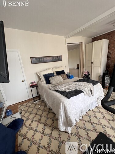 A bedroom with a large bed and a television.