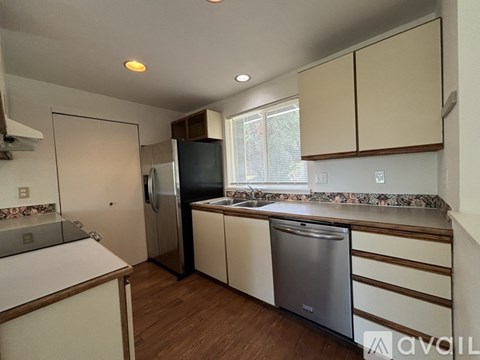 A kitchen with a refrigerator, sink, and dishwasher.