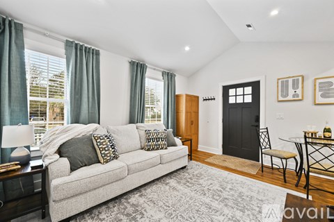 A living room with a grey couch and a black door.