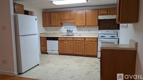 A kitchen with wooden cabinets and appliances.