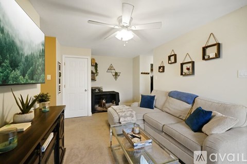 A living room with a couch, coffee table, and a painting on the wall.