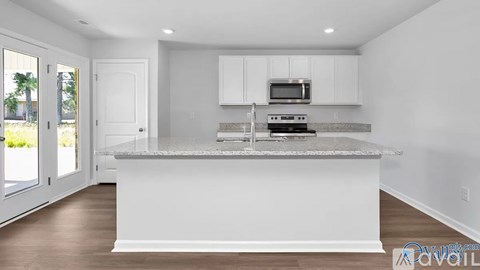 A kitchen with white cabinets and a granite countertop.